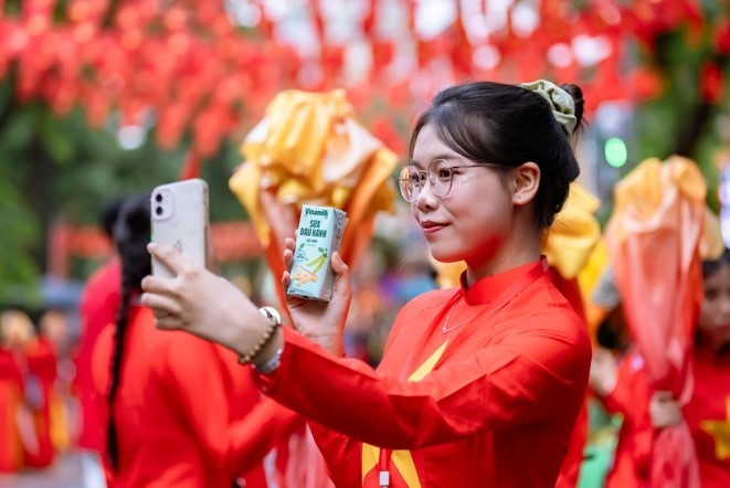 Các bạn trẻ tranh thủ selfie với các sản phẩm dinh dưỡng của Vinamilk. (Ảnh: Vi Nam/Vietnam+