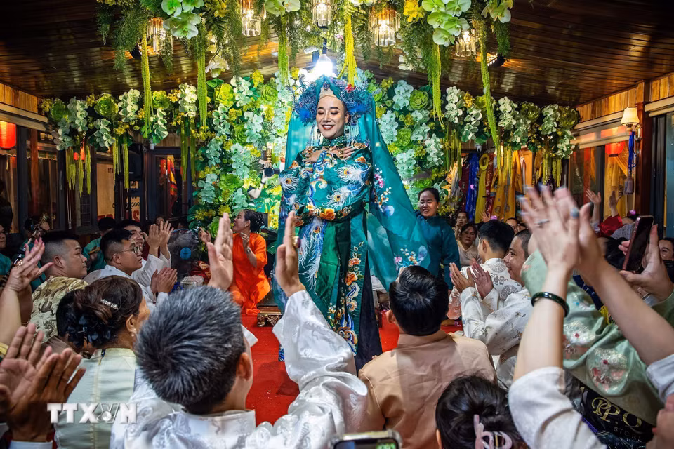 Không gian thực hành nghi lễ hầu đồng bên trong thuyền rồng náo nhiệt với âm thanh của hát chầu văn và tiếng reo hò của người xem. (Ảnh: Vân Chi/TTXVN phát)