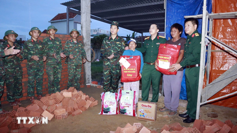Chỉ huy Trưởng Bộ chỉ huy Quân sự thành phố Đà Nẵng thăm động viên các chiến sĩ và hộ gia đình thực hiện giúp dân xây nhà sau mưa lũ. (Ảnh: Trần Tĩnh/TTXVN)