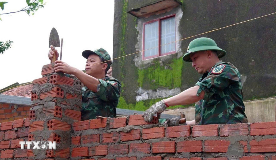 Lực lượng quân đội Bộ chỉ huy Quân sự thành phố Đà Nẵng giúp dân xây nhà sau mưa lũ. (Ảnh: Trần Tĩnh/TTXVN)