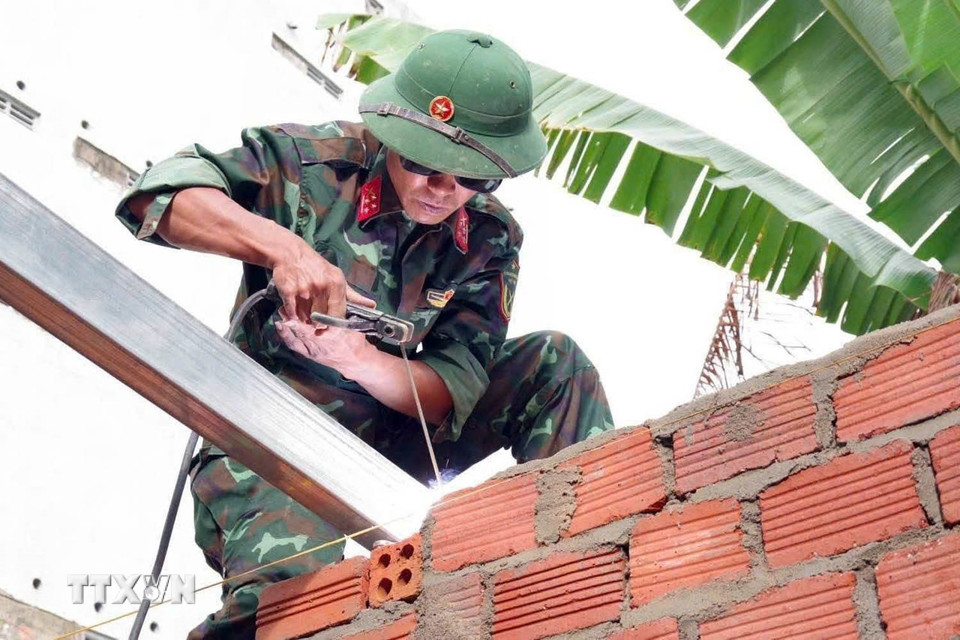 Lực lượng quân đội Bộ chỉ huy Quân sự thành phố Đà Nẵng giúp dân xây nhà sau mưa lũ. (Ảnh: Trần Tĩnh/TTXVN)