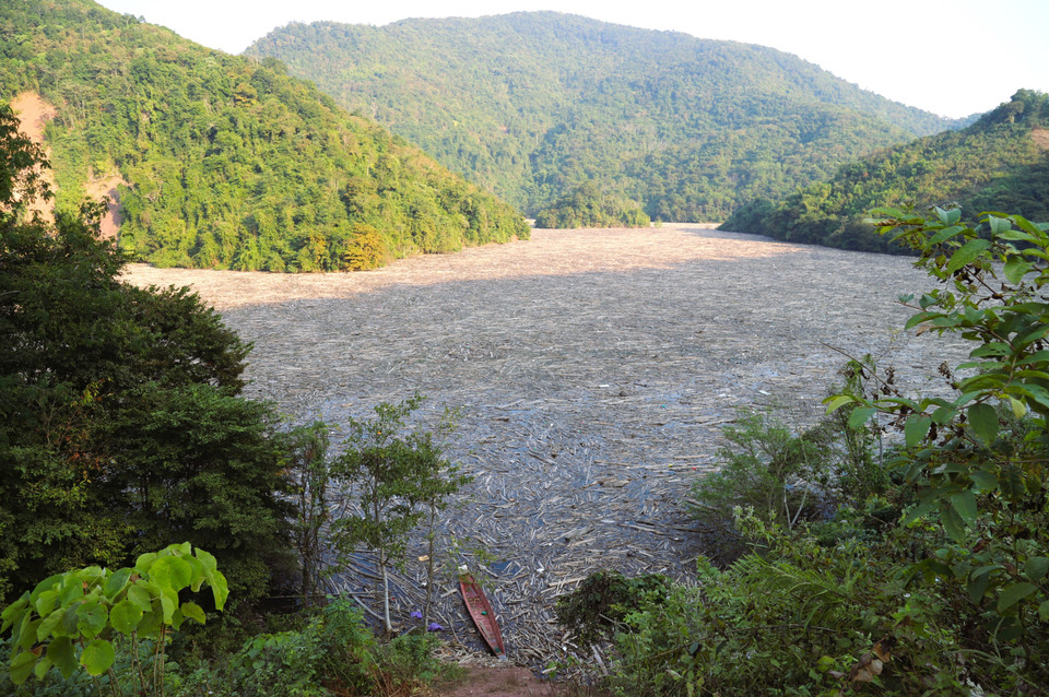 Rác, thân gỗ, cành khô các loại phủ kín, nêm cứng mặt sông Nậm Nơn thuộc lòng hồ Thủy điện Bản Vẽ khiến nhiều bến đò ngang, dọc thiết lập bên sông phải dừng hoạt động nhiều tháng nay. (Ảnh: Xuân Tiến/TTXVN)