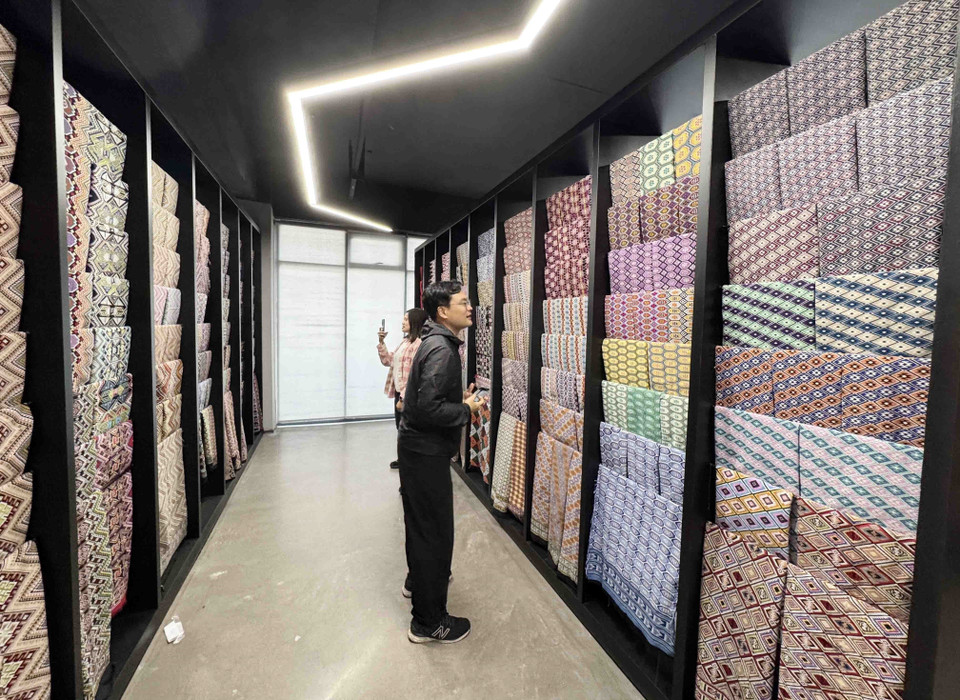 Du khách tìm hiểu về sản phẩm thổ cẩm Thổ Gia. (Ảnh: Công Tuyên/TTXVN)