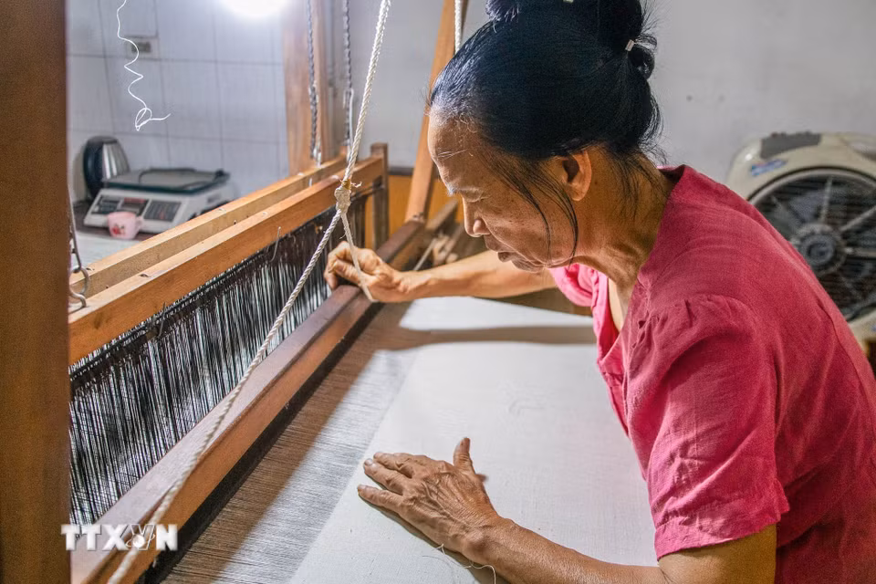 Người phụ nữ làng nghề miệt mài dệt vải. (Ảnh: Lan Anh/TTXVN phát)