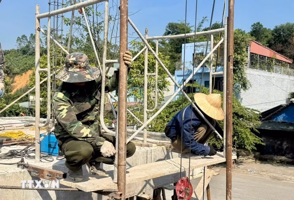 Các công nhân miệt mài làm việc trên công trường trong thời tiết nắng gắt. (Ảnh: Tuấn Anh/TTXVN)