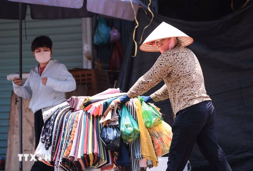 Những người bán hàng rong tại khu vực chợ Đồng Xuân rất vất vả trong điều kiện nền nhiệt độ tăng cao. (Ảnh: Hoàng Hiếu/TTXVN)