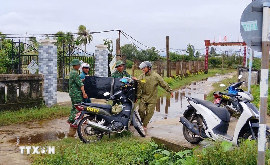 Đồn Biên phòng Tam Thanh, thành phố Đà Nẵng, giúp đỡ nhân dân di chuyển thiết bị điện dễ bị ngập nước đến nơi an toàn. (Ảnh: Đoàn Hữu Trung/TTXVN)
