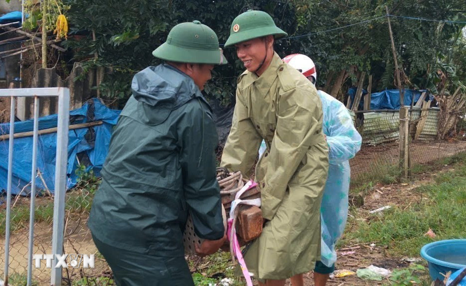 Đồn Biên phòng Tam Thanh, thành phố Đà Nẵng, giúp đỡ nhân dân di chuyển thiết bị điện dễ bị ngập nước đến nơi an toàn. (Ảnh: Đoàn Hữu Trung/TTXVN)