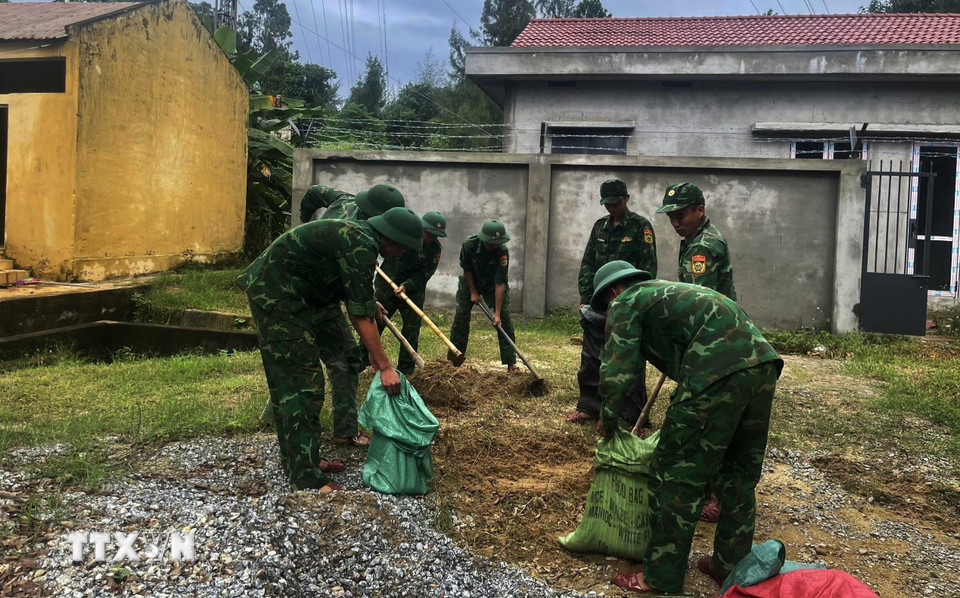 Đồn biên phòng cửa khẩu cảng Kỳ Hà sử dụng bao tải chứa đất đá và nước để chằng mái nhà khỏi bị gió bão 12 quăng quật. (Ảnh: Đoàn Hữu Trung/TTXVN)