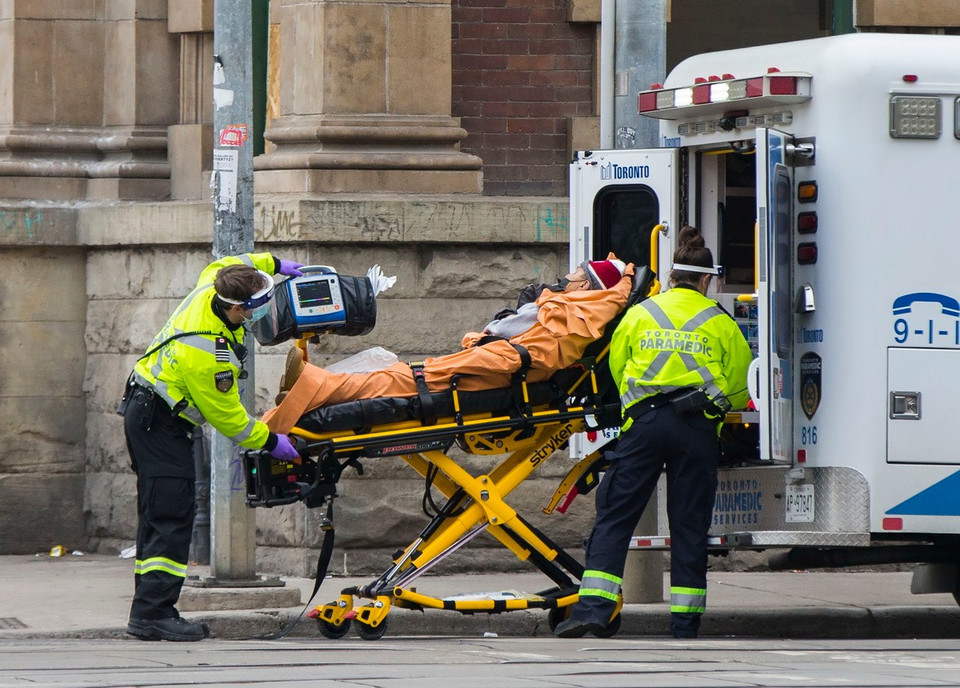 Chuyển bệnh nhân COVID-19 lên xe cứu thương tại Toronto, Ontario, Canada. (Ảnh: THX/TTXVN)