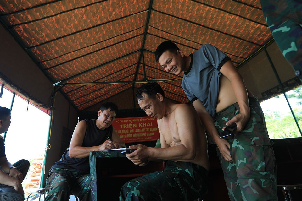 Khoảnh khắc vui vẻ của các cán bộ chiến sỹ tại nhà bạt sau những buổi tìm kiếm. (Ảnh: Trọng Đạt/TTXVN)