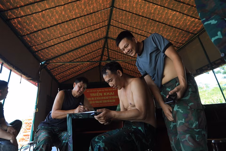 Khoảnh khắc vui vẻ của các cán bộ chiến sỹ tại nhà bạt sau những buổi tìm kiếm. (Ảnh: Trọng Đạt/TTXVN)