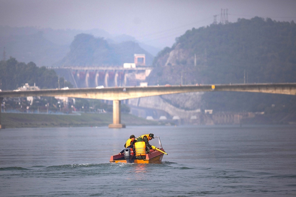 Các chiến sỹ trong đội dò tìm lên thuyền thực hiện nhiệm vụ trên dòng sông Đà phía hạ lưu thủy điện Hòa Bình. (Ảnh: Trọng Đạt/TTXVN)