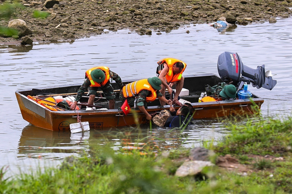 Lực lượng làm nhiệm vụ rà phá bom mìn, vật nổ thực hiện trục vớt phần nửa đầu quả bom có trọng lượng 2000 bảng Anh (gần 1 tấn). (Ảnh: Trọng Đạt/TTXVN)