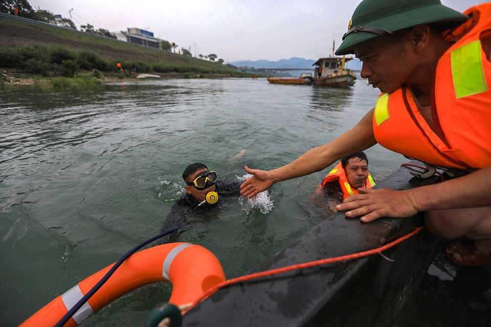 Lực lượng công binh, người nhái lặn tìm hàng giờ dưới nước khi bắt được các tín hiệu từ máy rà vật nổ kim loại. (Ảnh: Trọng Đạt/TTXVN)