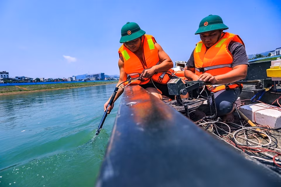 Lực lượng làm nhiệm vụ dùng trang thiết bị chuyên dụng thực hiện dò tìm trên tổng diện khoảng 29,5ha khu vực lòng sông hạ lưu thủy điện Hòa Bình. (Ảnh: Trọng Đạt/TTXVN)
