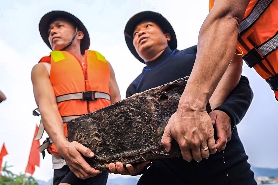 Một thùng đạn pháo còn nguyên ngòi nổ được các lực lượng tìm thấy và vận chuyển lên bờ. (Ảnh: Trọng Đạt/TTXVN)