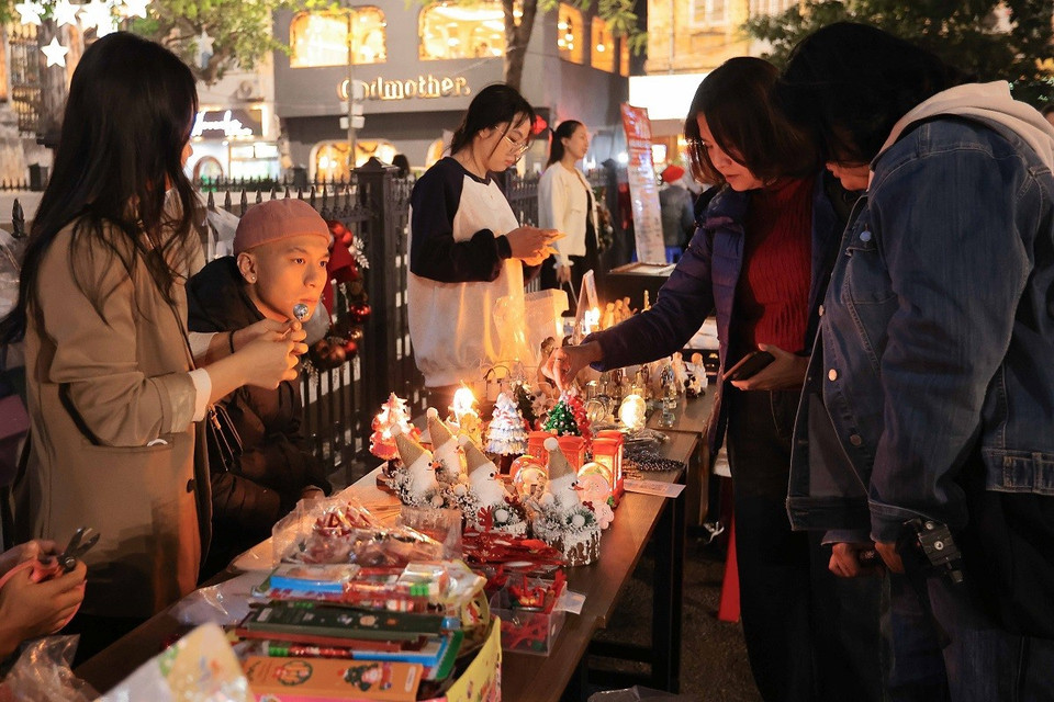 Người dân đến mua các phụ kiện liên quan đến Giáng sinh tại khu vực Nhà thờ Lớn. (Ảnh: Hoàng Hiếu/TTXVN)