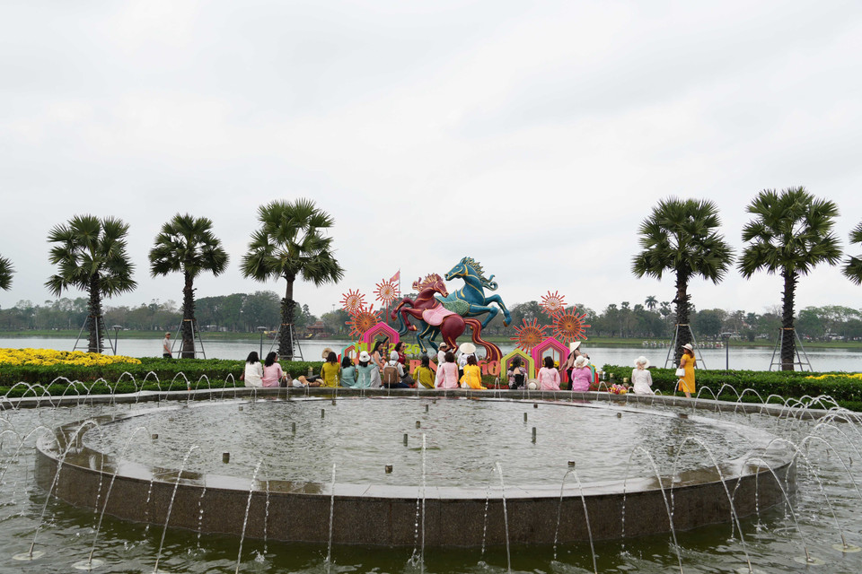 Du khách tham quan linh vật ngựa đặt ở bờ Nam sông Hương, thành phố Huế. (Ảnh: Nguyên Lý/TTXVN)