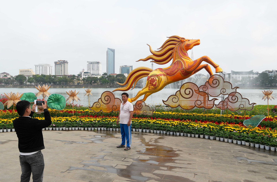 Du khách tham quan linh vật ngựa đặt ở bờ Bắc sông Hương, thành phố Huế. (Ảnh: Nguyên Lý/TTXVN)