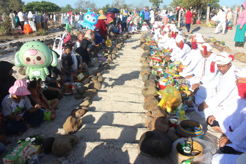 Từng dòng họ sẽ bày biện đồ cúng và ngồi thành 2 hàng dài để đọc kinh, cúng tổ tiên. (Ảnh: Hồng Hiếu/TTXVN)