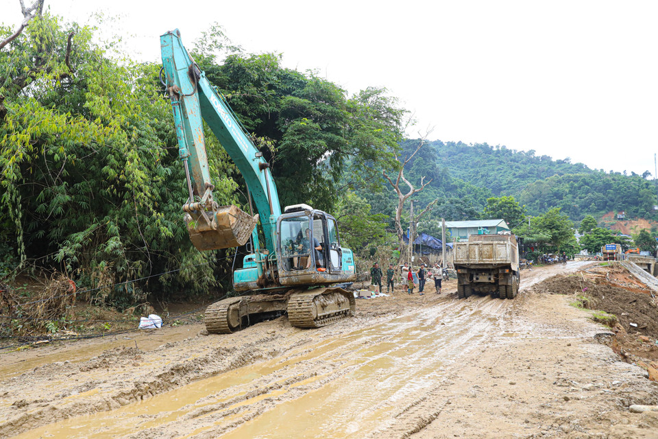 Công ty cổ phần đường bộ 2, tỉnh Điện Biên huy động nhiều phương tiện máy móc khẩn trương san lấp mặt bằng để sớm thông tuyến. (Ảnh: Phan Quân/TTXVN)