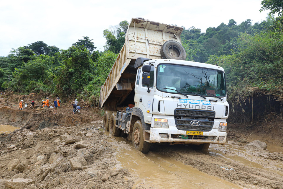 Công ty cổ phần đường bộ 2, tỉnh Điện Biên huy động nhiều phương tiện máy móc khẩn trương san lấp mặt bằng để sớm thông tuyến. (Ảnh: Phan Quân/TTXVN)