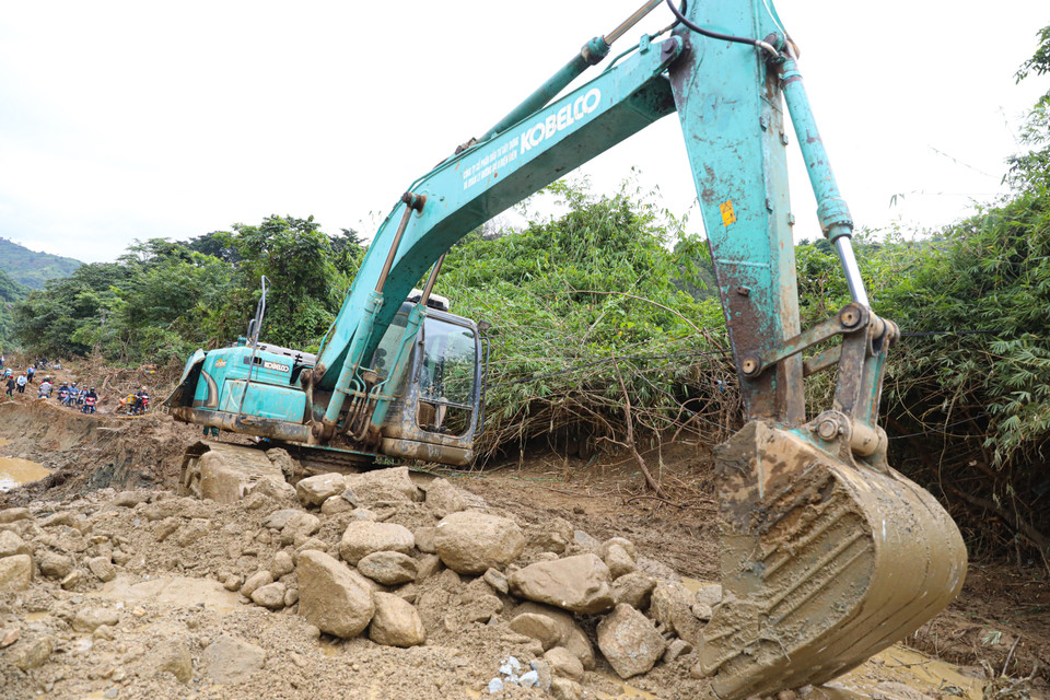 Công ty cổ phần đường bộ 2, tỉnh Điện Biên huy động nhiều phương tiện máy móc khẩn trương san lấp mặt bằng để sớm thông tuyến. (Ảnh: Phan Quân/TTXVN)