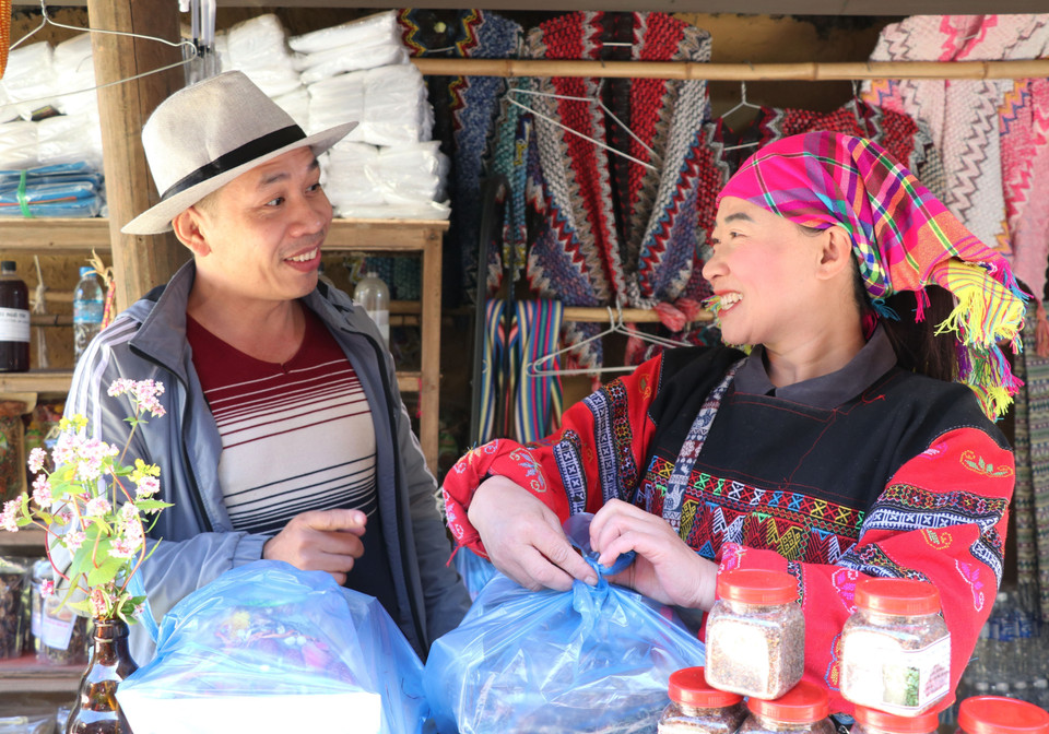 Du khách được người dân Lũng Cú giới thiệu những sản vật đặc trưng văn hóa nơi đây. (Ảnh: Đức Thọ/TTXVN)