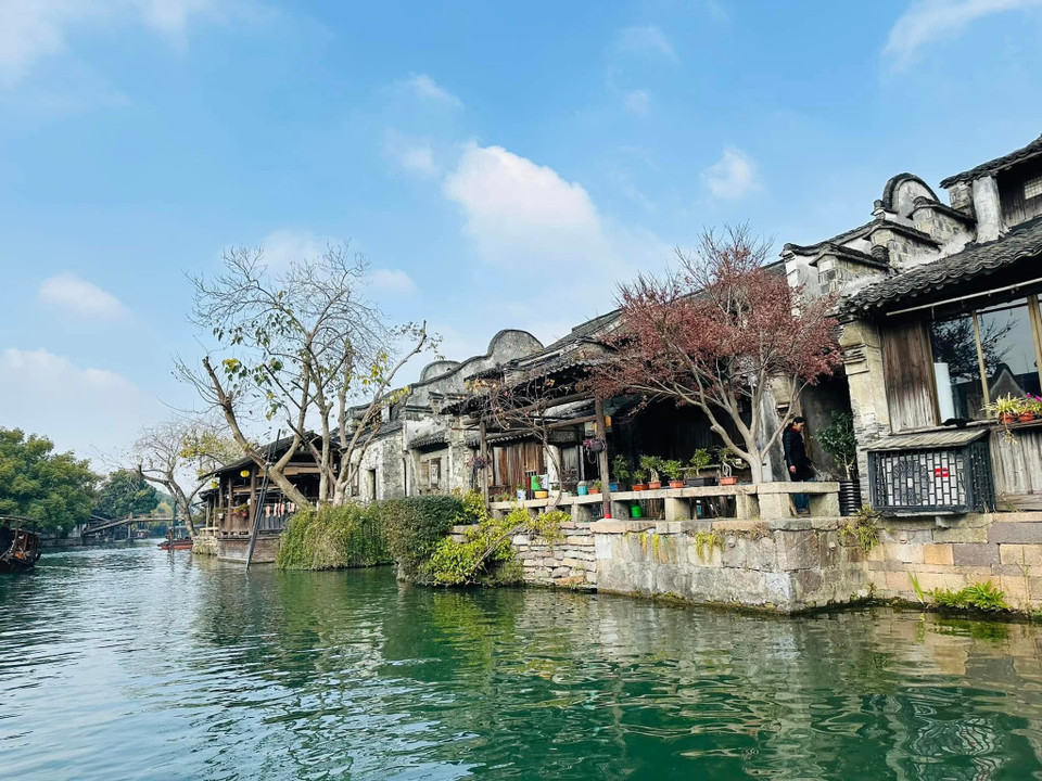 Tuy đã trải qua hàng nghìn năm thăng trầm nhưng Ô Trấn không hề mất đi diện mạo cổ xưa với những cây cầu, trụ đá, cửa sổ gỗ được trạm khắc hoa văn tinh tế. (Ảnh: Anh Quang/Vietnam+)