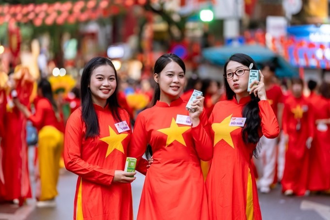Các bạn trẻ chia sẻ rằng các bạn ấn tượng với mẫu mã bao bì của các sản phẩm dinh dưỡng Vinamilk. Các bạn cảm thấy rất vui và tự hào khi hôm nay được “diễu hành” cùng thương hiệu sữa quốc dân trong ngày vui toàn dân. (Ảnh: Vi Nam/Vietnam+)