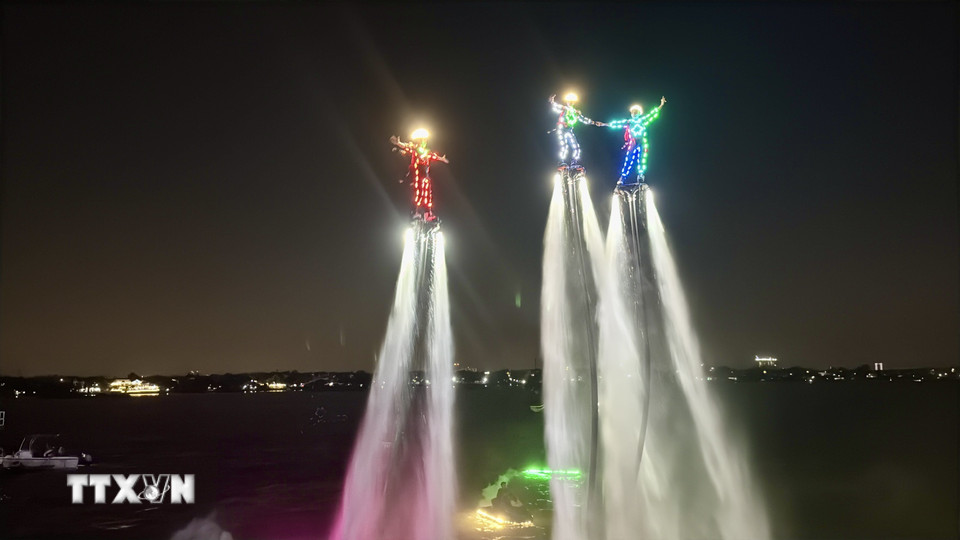 Các vận động viên Flyboard trình diễn trên dòng sông Đồng Nai. (Ảnh: Lê Xuân/TTXVN)