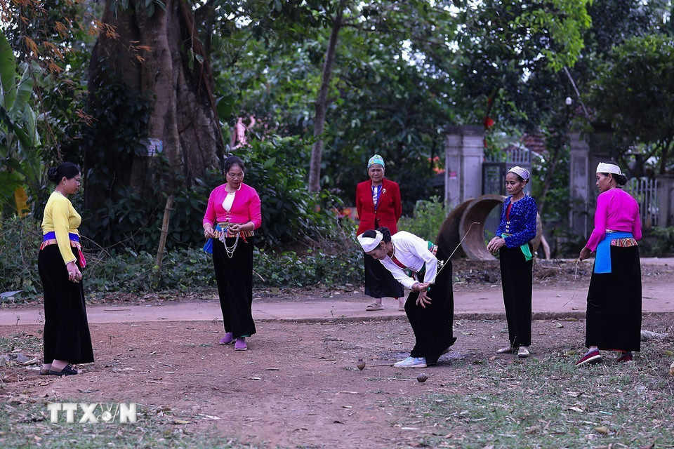Người chơi cuốn dây quanh con cù rồi giật mạnh để làm cù quay trên mặt đất sau đó người chơi trong đội dùng cù của mình tung mạnh để va vào cù của đối phương khiến cù của đối phương ngừng quay. (Ảnh: Trọng Đạt/TTXVN)