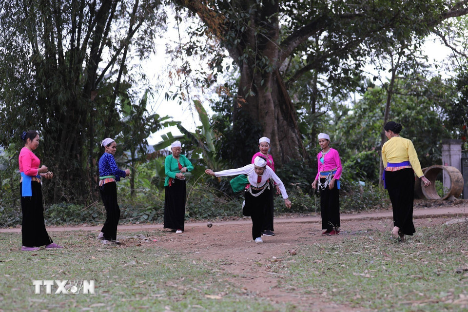 Người chơi cuốn dây quanh con cù rồi giật mạnh để làm cù quay trên mặt đất. (Ảnh: Trọng Đạt/TTXVN)