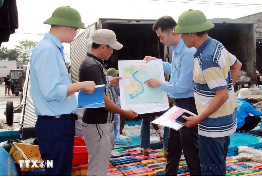 Trao tặng bản đồ cho ngư dân Nam Định trước khi ra khơi. (Ảnh: Nguyễn Lành/TTXVN)