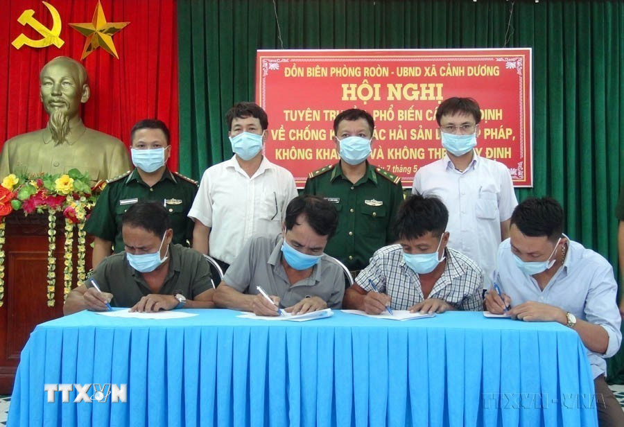 Ký cam kết giữa Đồn Biên phòng Roòn, UBND xã Cảnh Dương và các hộ ngư dân Quảng Bình về “Khai thác hải sản bất hợp pháp, không khai báo và không theo quy định” (IUU). (Ảnh: Đức Thọ/TTXVN)