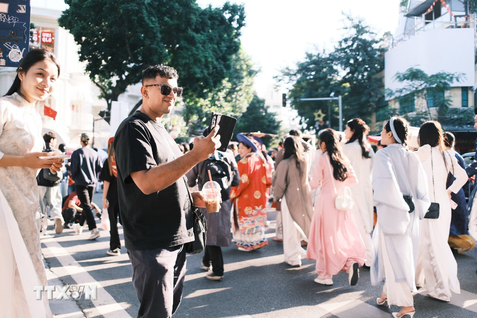 Du khách ngắm nhìn và lưu lại khoảnh khắc trong lễ diễu hành. (Ảnh: Phạm Tuấn Anh/TTXVN)