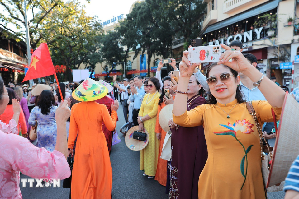 Người dân hứng thú, ghi lại khoảnh khắc trong lễ diễu hành. (Ảnh: Lê Đông/TTXVN)