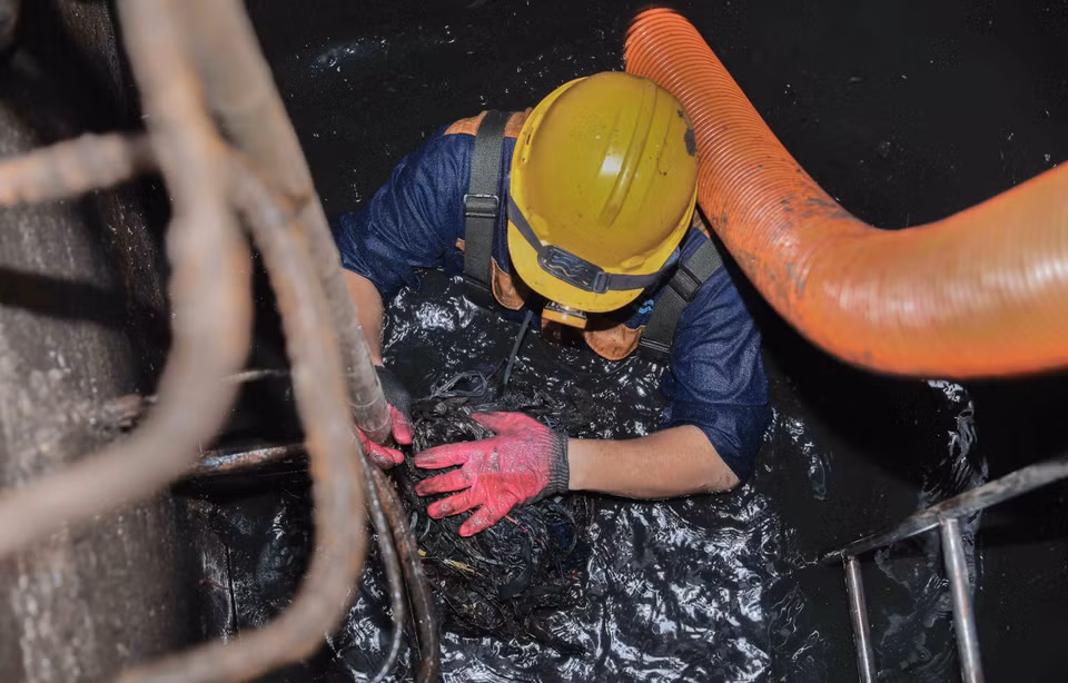 Trực tiếp ngâm mình dưới dòng nước cống đen ngòm để khơi thông dòng chảy, đảm bảo cuộc sống bình yên cho người dân Thủ đô. (Ảnh: Phan Phương/TTXVN)