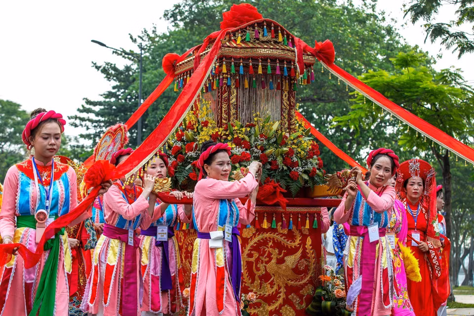 Kiệu rước Thánh Mẫu và Hội đồng Tứ phủ được hộ tống bởi nhiều người, tiến về phía Công viên Thương Bạc. (Ảnh: Vân Chi/TTXVN phát)