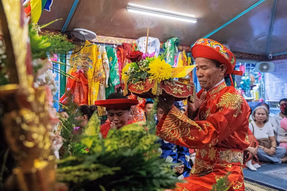 Thực hành nghi lễ hầu đồng và cầu nguyện bên trong các bằng, án. (Ảnh: Vân Chi/TTXVN phát)