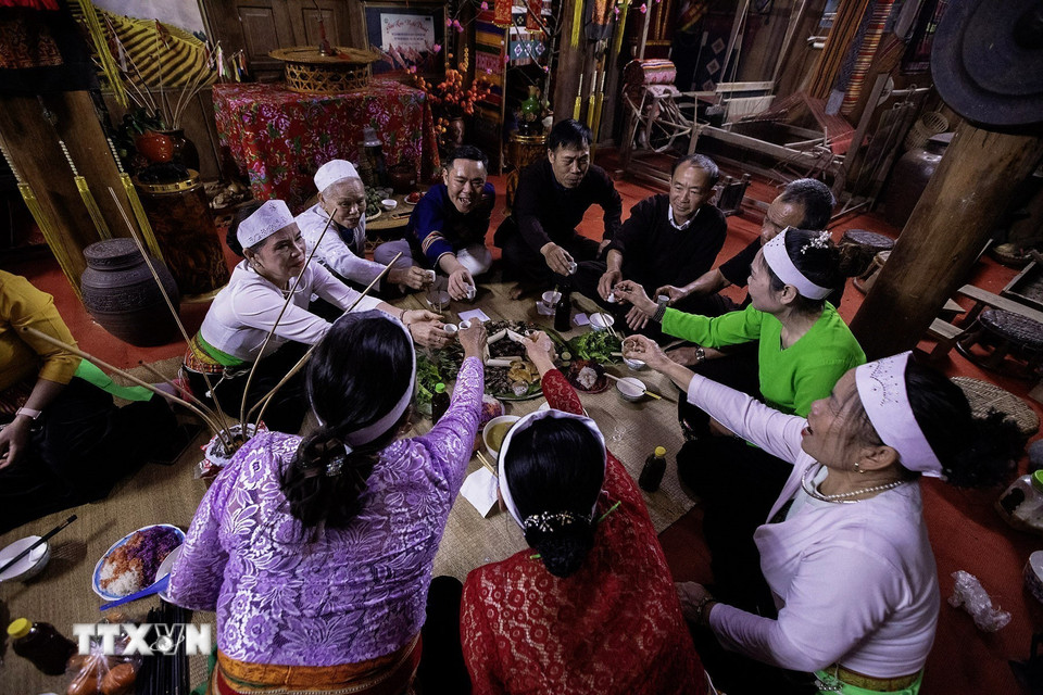 Phường bùa sau khi sắc bùa chúc tết sẽ được chủ nhà mời nâng chén chung vui cùng gia đình trong những ngày xuân. (Ảnh: Trọng Đạt/TTXVN)