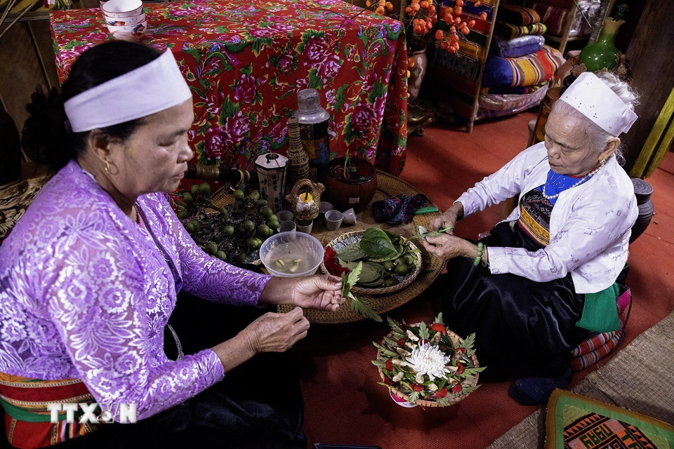 Các Mế Mường (phụ nữ cao tuổi) ngồi têm trầu cánh phượng chuẩn bị cho mâm lễ tết. (Ảnh: Trọng Đạt/TTXVN)