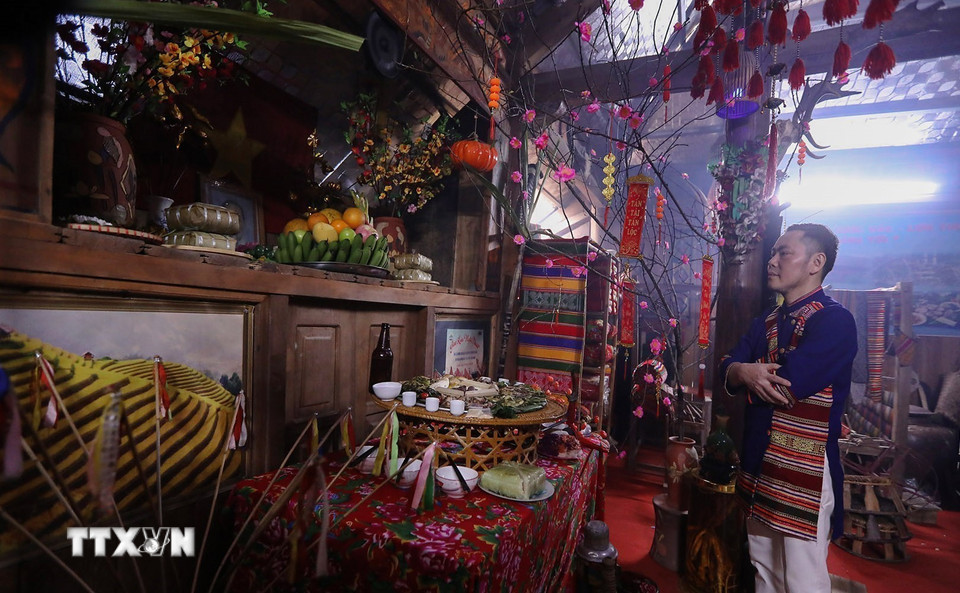 Thầy cúng làm lễ dâng lên tổ tiên mâm cỗ cúng trong đêm giao thừa. (Ảnh: Trọng Đạt/TTXVN)