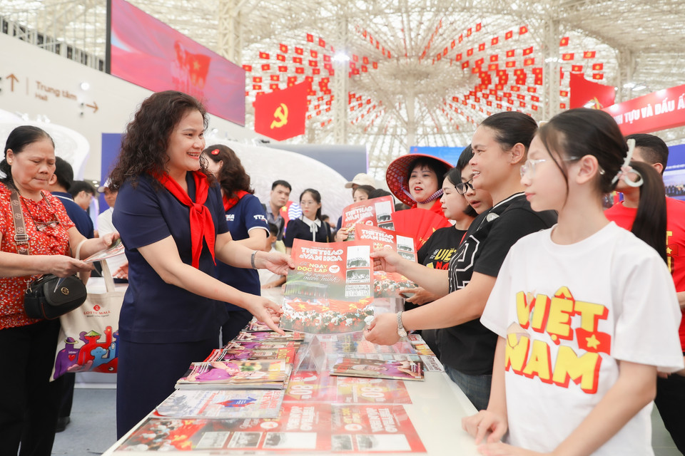 Phó Tổng Giám đốc TTXVN Nguyễn Thị Sự trực tiếp trao đổi, chia sẻ thông tin và tặng các ấn phẩm báo chí cho các bạn trẻ. (Ảnh: Phan Phương/TTXVN)