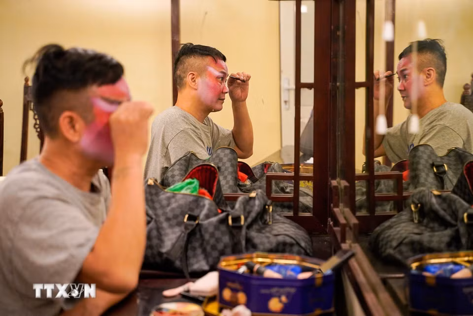 Diễn viên hóa trang khuôn mặt tùy theo tính cách vai diễn của mình. (Ảnh: Khánh Hoà/TTXVN)
