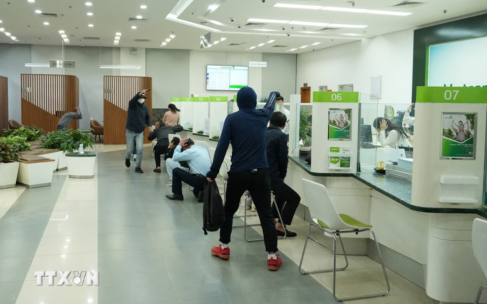 Hai đối tượng dùng hung khí đe dọa và cướp tài sản trong tình huống diễn tập. (Ảnh: Đức Phương/TTXVN)