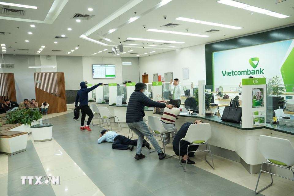 Tình huống hai đối tượng dùng hung khí đe dọa và cướp tài sản. (Ảnh: Đức Phương/TTXVN)