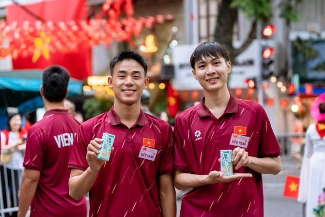 Các đại biểu của Khối Văn hóa – Thể thao tranh thủ tiếp ứng dinh dưỡng trong giờ giải lao. Nước mát, sữa ngon và giàu dinh dưỡng của Vinamilk giúp mọi người tràn đầy năng lượng suốt lễ diễu hành. (Ảnh: Vi Nam/Vietnam+