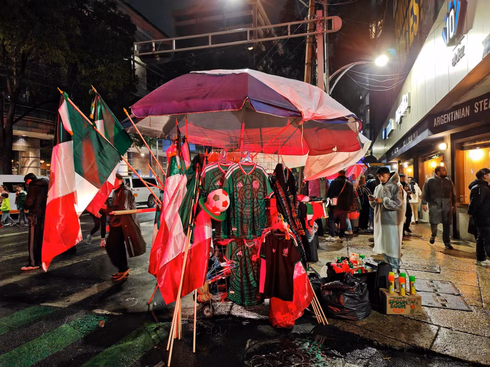 Cờ, mũ, kèn và áo đấu mang màu cờ Mexico được bày bán nhộn nhịp trong trận đấu Mexico- Ecuador. (Ảnh: Phương Lan/TTXVN)
